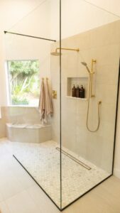 Modern shower with frameless glass and gold fixtures after Houston shower replacement