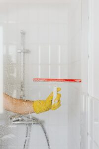 Person using squeegee to clean Houston shower doors